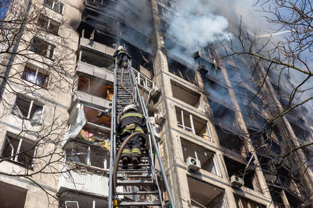 KYIV, UKRAINE - Mar. 15, 2022: War in Ukraine. Firefighters fighting a fire in a residential building that was hit by a Russian shell.のeditorial素材