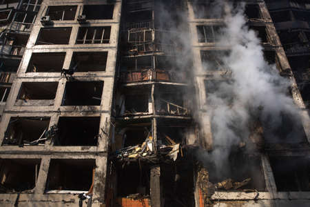 KYIV, UKRAINE - Mar. 15, 2022: War in Ukraine. General view of a badly damaged residential building in the smoke from the fire that was hit by a Russian shell.のeditorial素材