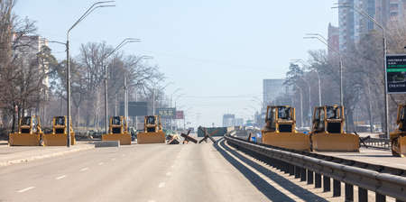 KYIV, UKRAINE - Mar. 15, 2022: War of Russia against Ukraine. Excavators, concrete blocks and anti-tank hedgehogs on the streets of Kyivのeditorial素材