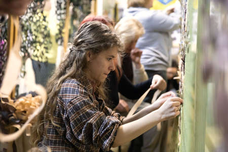 KYIV, UKRAINE - Apr. 01, 2022: A group of volunteers in a shelter making camouflage net, from...