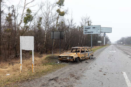 KYIV REG., UKRAINE - Apr. 02, 2022: A destroyed and burnt cars seen on a Kyiv-Zhytomyr highway 20 km from Kyiv.のeditorial素材