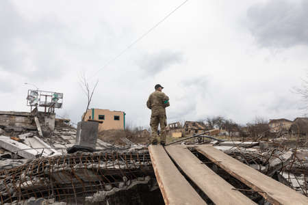IRPIN, UKRAINE - Apr. 10, 2022: Ukrainian servicemen is on duty near a destroyed bridge outside the recaptured city of Irpinのeditorial素材