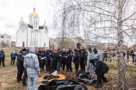 BUCHA, UKRAINE - Apr. 12, 2022: Genocide in Bucha. Forensic police officers exhume bodies in Bucha, outskirts of Kyiv, Ukraine.のeditorial素材