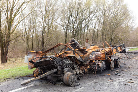 War in Ukraine. Burnt out cars on the edge of the road. Traces of the Russian army invasion of...