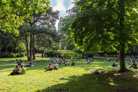 VIENNA, AUSTRIA - May 26, 2022: Young people are relaxing in popular public park on sunny day. People relaxing in a park in the city center.のeditorial素材