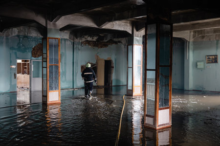 KHARKIV, UKRAINE - Jul. 30, 2022: Firefighter works in highly damaged specialized school following night Russian rocket attach on Kharkiv, Ukraineのeditorial素材