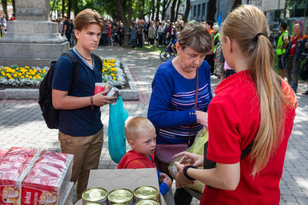 KHARKIV, UKRAINE - Aug. 02, 2022: People waiting for cans of canned food. Volunteer organization Caritas Ukraine distributes food to the needy in Kharkivのeditorial素材