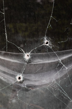 KHARKIV, UKRAINE - Jul. 30, 2022: Window with holes from shell fragments. Kharkov during the war with the Russian Federation.のeditorial素材