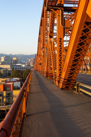 PORTLAND, OREGON, USA - Oct. 14, 2022: Farms metal vehicular and pedestrian bridge painted red. Broadway Bridge is a Rall-type bascule bridge spanning the Willamette River in Portland built in 1913のeditorial素材