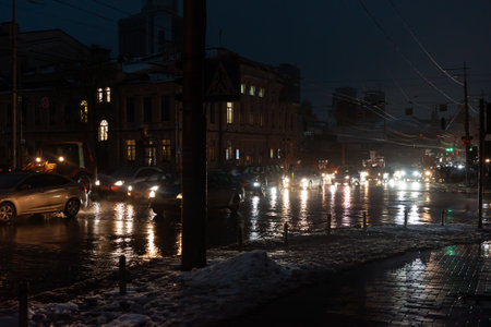 KYIV, UKRAINE - Dec. 16, 2022: Dark streets of Kyiv without street lighting. Only car headlights and some building windows are visible at night during the blackout.のeditorial素材