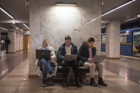 KYIV, UKRAINE - Dec. 16, 2022: Young people work on computers at a metro station in Kyiv where Internet, communications, electricity, drinking water and sanitary facilities are available at blackouのeditorial素材