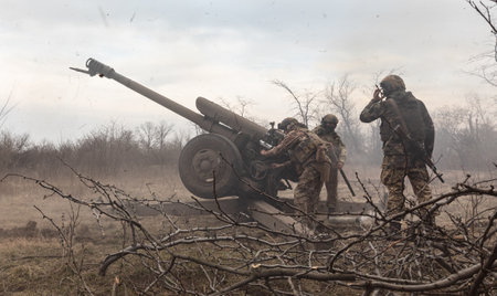 DONETSK REG., UKRAINE - Mar. 21, 2023: War of Russia against Ukraine. Artillerymen from the Ukrainian armed forces shooting from 122 mm howitzer D-30 into Russian positions near Bakhmutのeditorial素材