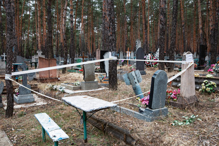 Unexploded rocket fenced for safety with warning tape can be seen in the cemetery of Izyum, Kharkiv reg, Ukraineのeditorial素材
