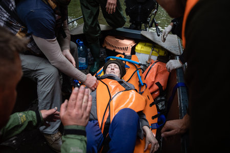 KHERSON, UKRAINE - Jun. 12, 2023: Lifeguards are seen evacuating an elderly helpless woman in a boat from the flood zone.のeditorial素材