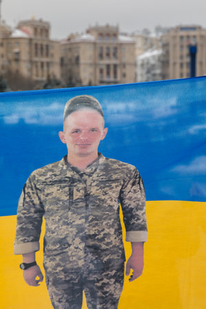 KYIV, UKRAINE - Dec. 10, 2023: Free Azov rally in support of Ukrainian prisoners of war. A portrait of a prisoner of war hero is seen printed on the flag of Ukraineのeditorial素材