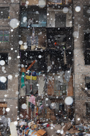 KYIV, UKRAINE - Jan. 05, 2024: Volunteers and residents clear debris and board up the windows of the residential block that was hit by Russian missile in Kyiv, Ukraineのeditorial素材