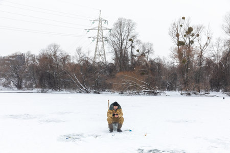 KYIV, UKRAINE - Jan. 14, 2024: Ice fishing on the Dnieper River in Kyiv. Despite the Russian Federations ongoing war against Ukraine, Kyiv, the capital of Ukraine, continues to live a peaceful life.のeditorial素材