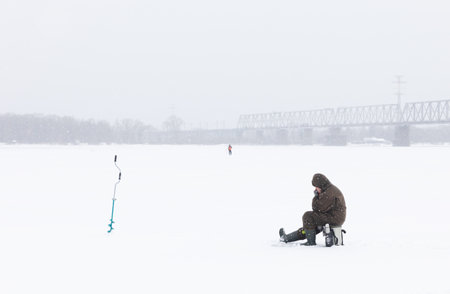 KYIV, UKRAINE - Jan. 14, 2024: Ice fishing on the Dnieper River in Kyiv. Despite the Russian Federations ongoing war against Ukraine, Kyiv, the capital of Ukraine, continues to live a peaceful life.のeditorial素材