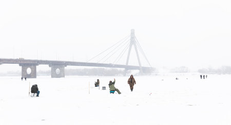 KYIV, UKRAINE - Jan. 14, 2024: Ice fishing on the Dnieper River in Kyiv. Despite the Russian Federations ongoing war against Ukraine, Kyiv, the capital of Ukraine, continues to live a peaceful life.のeditorial素材