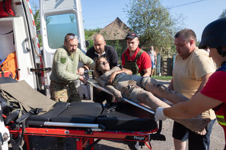 Bilopillya Sumy reg, UKRAINE - Aug. 18, 2024: Rescuers are seen evacuating a wounded woman on a stretcher after Russian troops bombed civilians.のeditorial素材