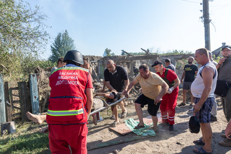Bilopillya Sumy reg, UKRAINE - Aug. 18, 2024: Rescuers are seen evacuating a wounded woman on a stretcher after Russian troops bombed civilians.のeditorial素材