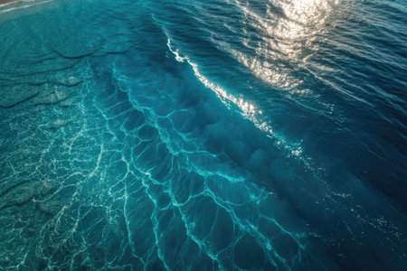 Sunlight reflects off the gently rippling water, illuminating a vivid expanse of turquoise blue....