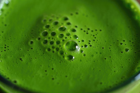 A close up view of a vibrant green drink with bubbles, showcasing its texture and freshness. The...