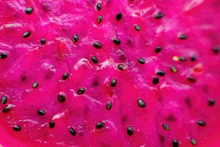 A vibrant close up of a dragon fruit's juicy, seed filled interior, showcasing its vivid pink hues and textures.の写真素材