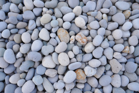 A close up view of a collection of smooth, light colored rocks.