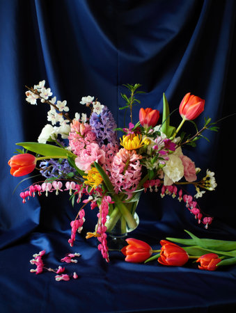 A vibrant floral arrangement features an array of colorful blooms, gracefully set against a deep blue backdrop.の写真素材
