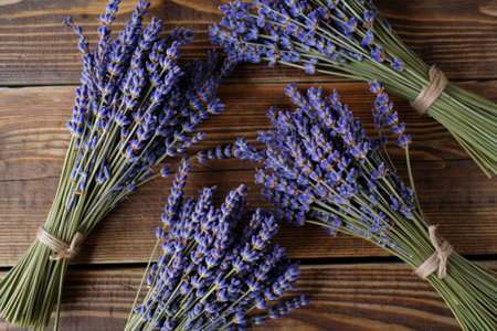 A beautiful display of lavender bouquets, tied with twine, arranged on a rustic wooden surface.の写真素材
