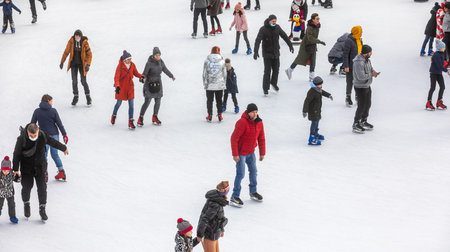 KYIV, UKRAINE - Dec. 27, 2020: Ice-skating people. People have fun in ice arena at the city ice rink. New Years holidays in city Kyiv.の写真素材