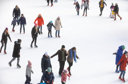 KYIV, UKRAINE - Dec. 27, 2020: Ice-skating people. People have fun in ice arena at the city ice rink. New Years holidays in city Kyiv.の写真素材
