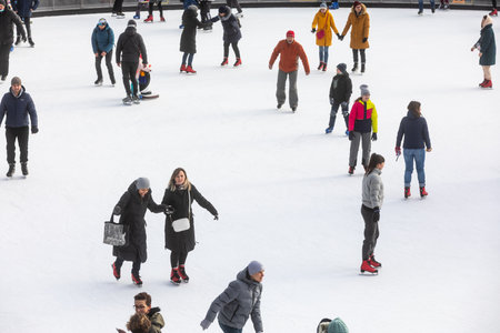 KYIV, UKRAINE - Dec. 27, 2020: Ice-skating people. People have fun in ice arena at the city ice rink. New Years holidays in city Kyiv.の写真素材
