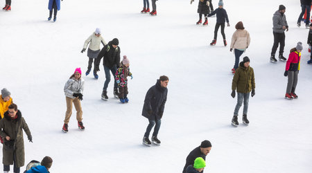 KYIV, UKRAINE - Dec. 27, 2020: Ice-skating people. People have fun in ice arena at the city ice rink. New Years holidays in city Kyiv.の写真素材