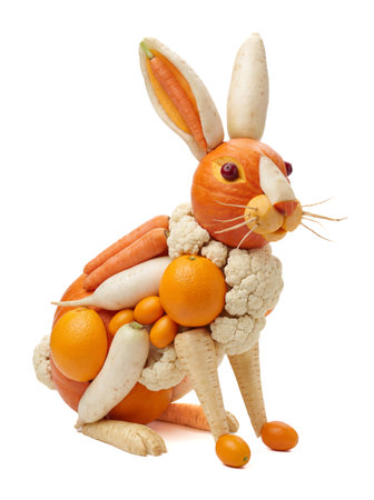 A three-dimensional sculpture of a rabbit is composed entirely of various fresh fruits and vegetables, presented on a pristine white background.の写真素材