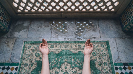 Two arms with hands raised upward in supplication are positioned over a worn, green and beige...