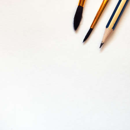 Paint equipment on white background. Pencil and paintbrushes on the watercolor paper.の写真素材