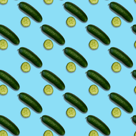 A pattern of fresh cucumber. Whole and sliced cucumbers on a blue background. view from above.の写真素材