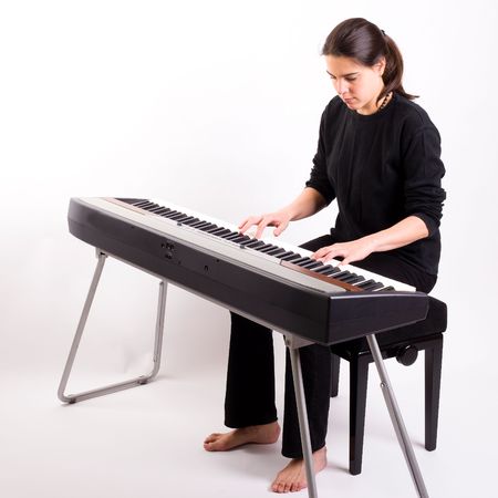 Young woman plays on an electric pianoの写真素材