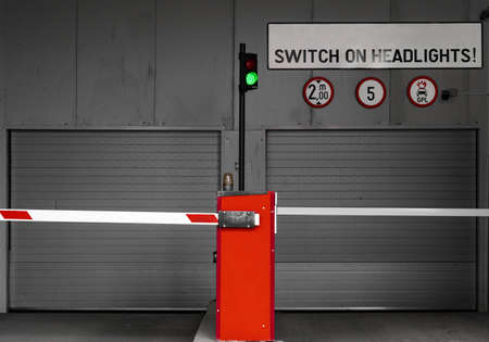 Subterranean car parking garage entry gate with switch on headlights sign and green lightの写真素材