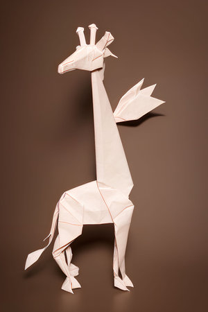 Paper origami giraffe on a brown background. Studio shot.の写真素材