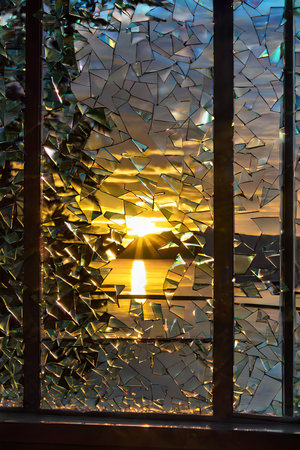 broken glass on the window in the rays of the setting sun.の写真素材