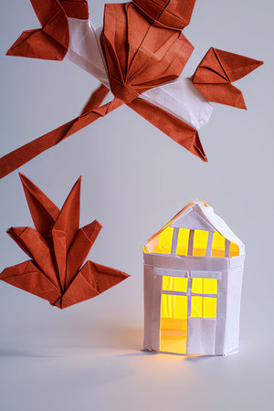 Origami house and origami birds on grey background. Real estate concept.の写真素材