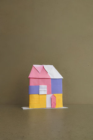 Paper origami house on gray background. Minimal creative concept.の写真素材