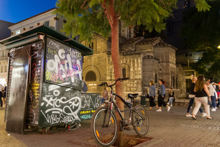 Athens, Greece - September 29, 2016: Parked bicycle, graffiti and people passing by the Church of Panagia Kapnikarea, an ancient church in Athens, Greeceのeditorial素材