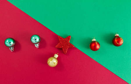 Christmas star and balls on green and red background top view. Minimalist style. Diagonal separation top left to bottom rightの写真素材
