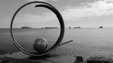 LImassol, Cyprus - 30 November, 2017: Frozen Wave Sculpture by Victor Bonato in Molos Park at Promenade alley in Limassol, Cyprus and ships in the distance. The sculpture is developing into a symbol of the seaside city.のeditorial素材