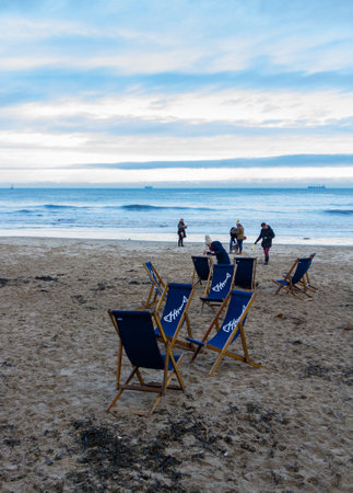 Tynemouth, United Kingdom - 30 December, 2017: King Edward's Bay winter morning scene of beach chairs and people taking their dogs for a walkのeditorial素材