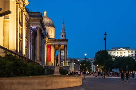 London, England - August 4, 2018: Evening side-view of the National Gallery at Trafalgar Square, London, as people stroll by.のeditorial素材